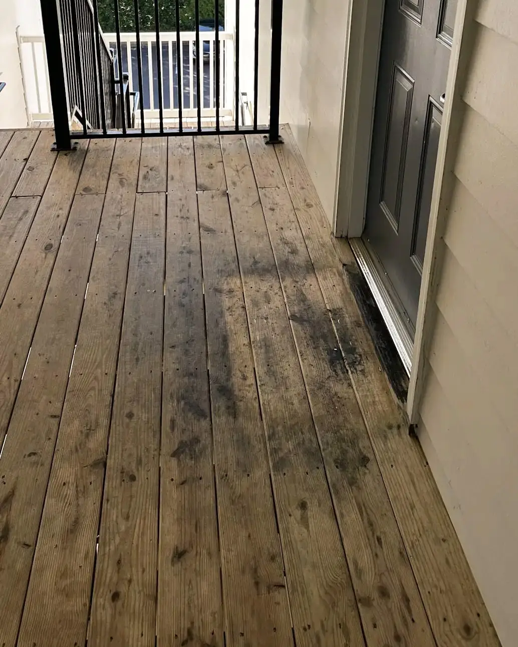 Wood apartment breezeway with staining before exterior cleaning
